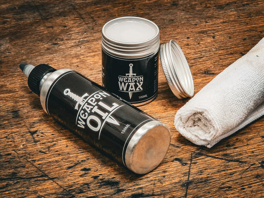 Raven Forge Weapon Oil, Weapon Wax and a cloth on a workbench