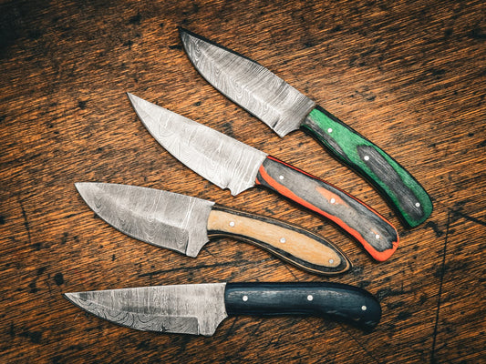 Four Damascus steel knives with coloured hardwood handles