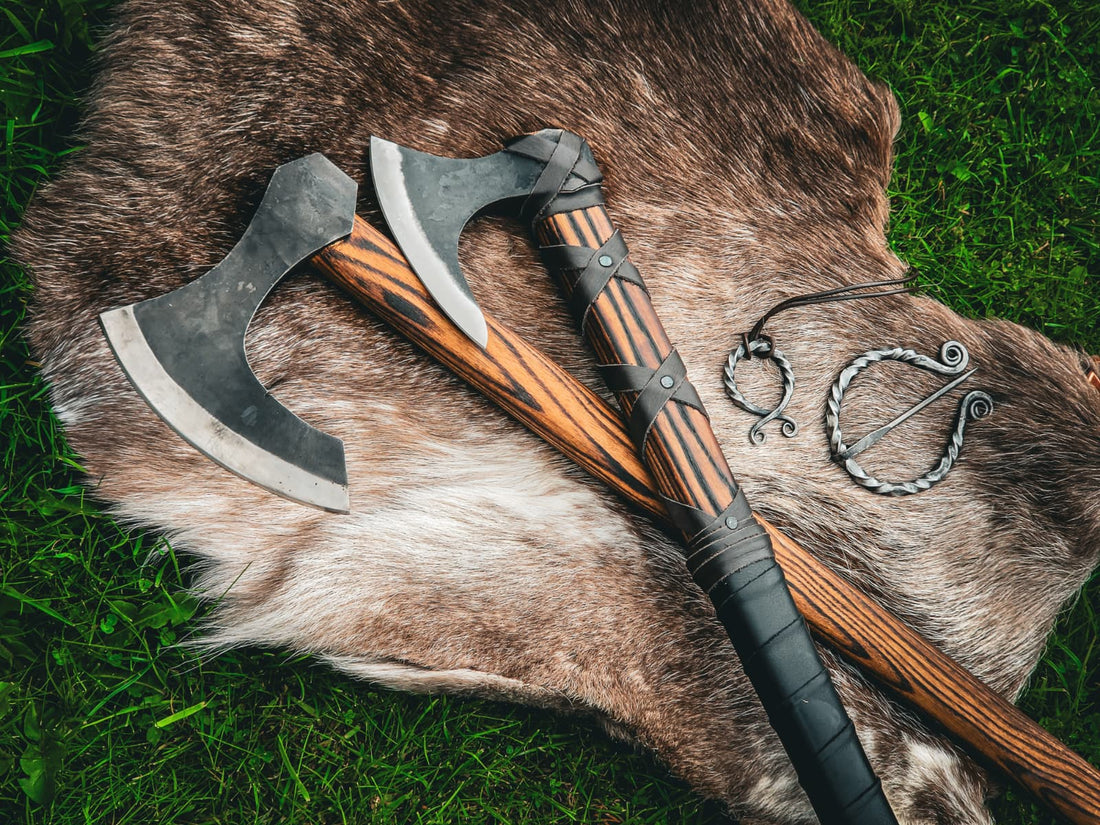 Two Viking axes and iron cloak pins laid on a fur throw